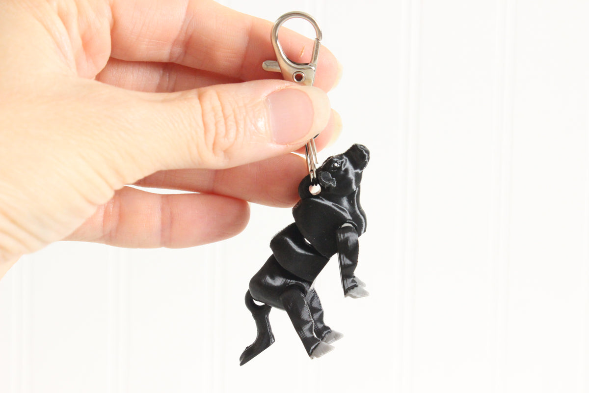 Black Angus cow keychain held in a person's hand for size reference 